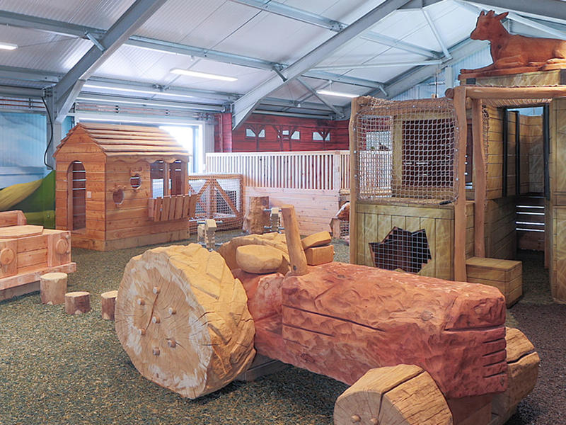 Wooden play equipment inside the Playbarn