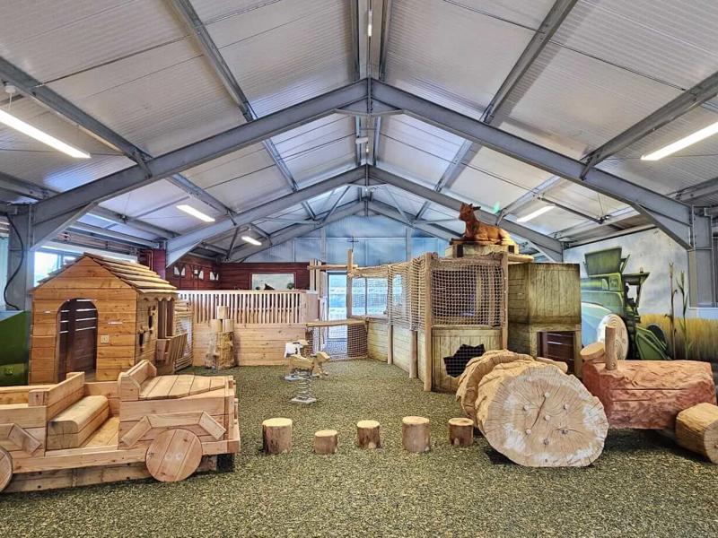 Indoor play barn with wooden play equipment
